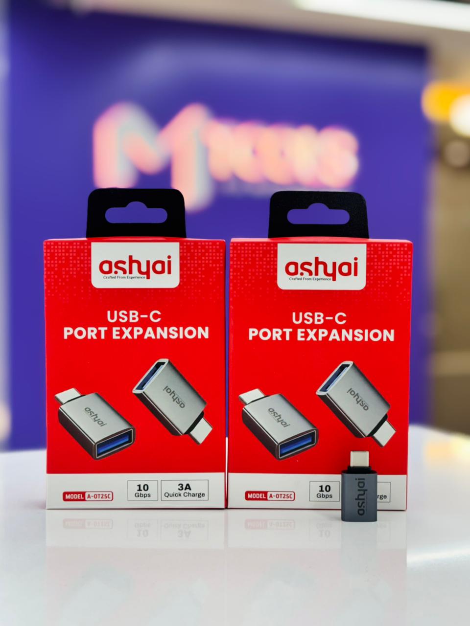 Close-up of Ashyai silver USB-C to USB-A adapter connected to a smartphone (A-OTG25C).
